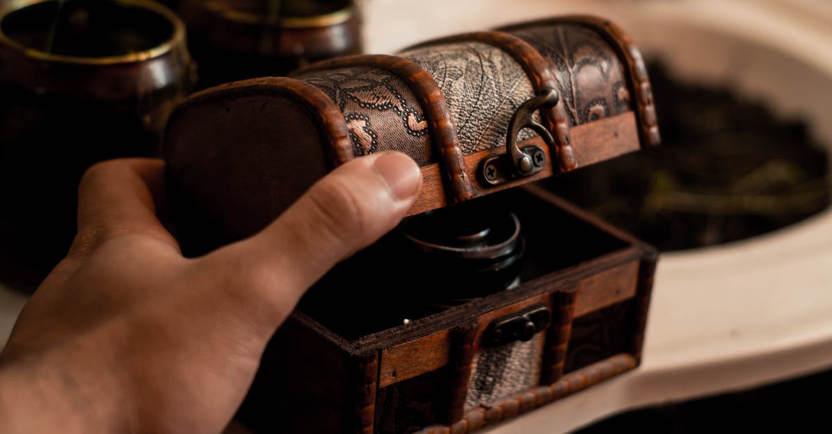 How do I open the chest in the Library? - Crop anonymous male artisan opening small antique wooden chest placed on table at home