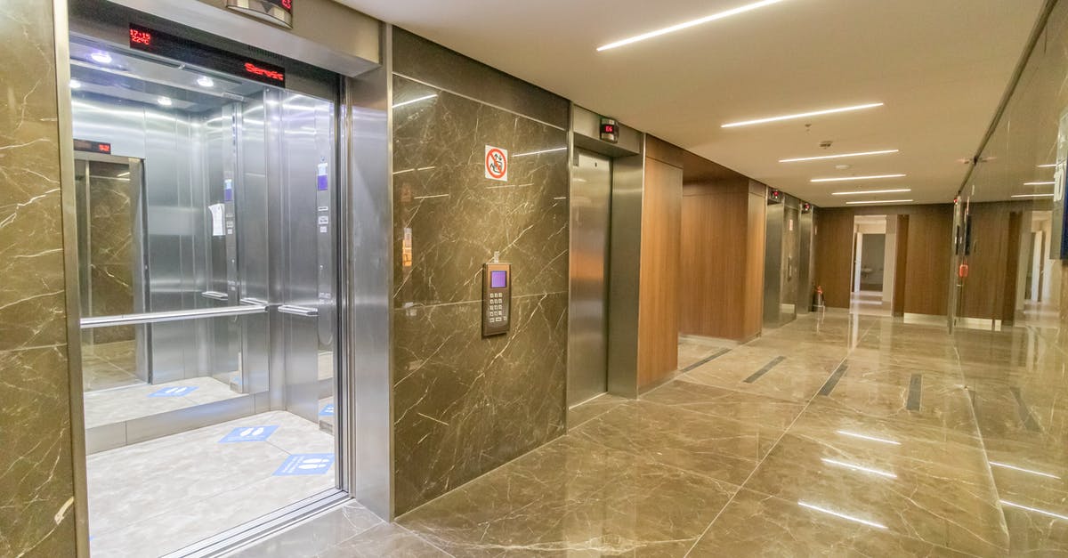 How do I open this secret door in the first level? - Interior of empty hallway with marble till in wall and floor with opened metal doors of elevator in multistory building How do I open this secret door in the first level? - Interior of empty hallway with marble till in wall and floor with opened metal doors of elevator in multistory building