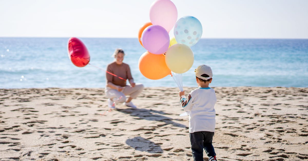 How Do I Play Forza Horizon 4? - Faceless boy with balloons on beach with anonymous mother