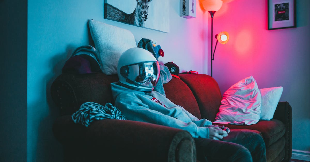 How do I play Minecraft with people online, besides using a server? [duplicate] - Anonymous guy in VR helmet sitting on sofa with controller while playing video game in cozy room with dark light