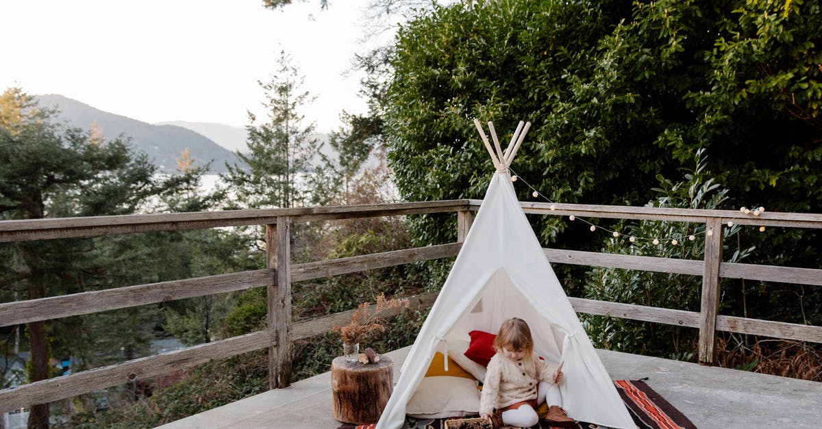 How do I play Mountain on linux? - Adorable little kid sitting on rug in wigwam located on terrace with wooden border and scenic view