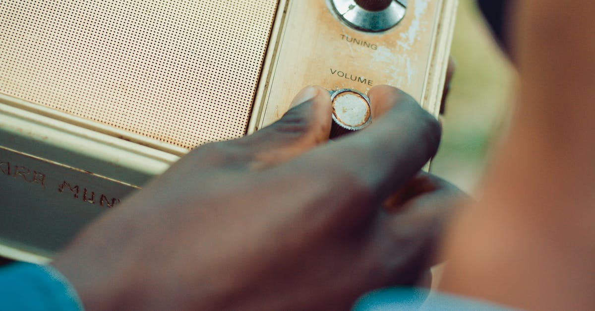 How do I power up the radio transmitter? - Person Holding Volume Knob