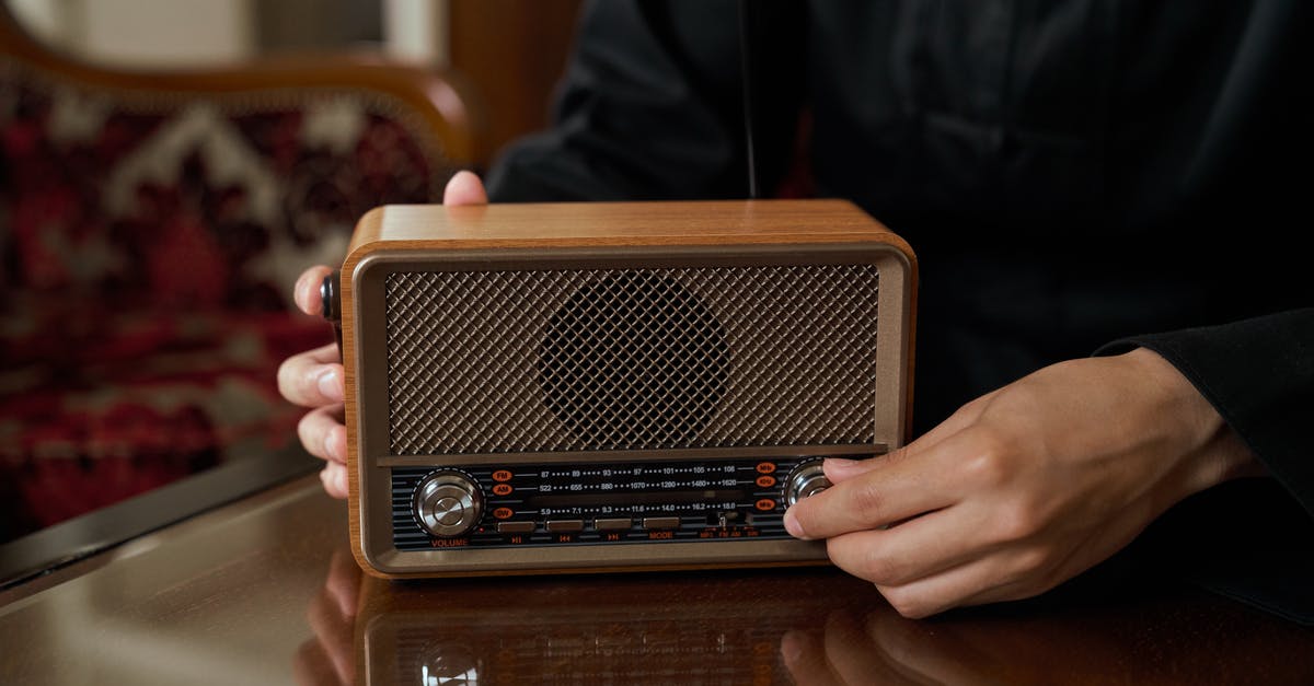 How do I power up the radio transmitter? - Unrecognizable Male Hand Putting Up Volume on Transistor Radio