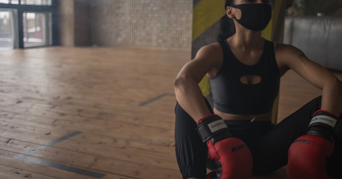 How do I prevent physics glitches in Trials Fusion? - African American female boxer in protective mask resting on floor after training in fitness center
