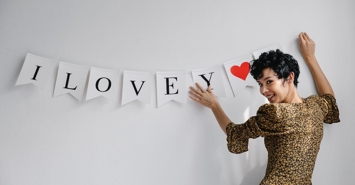 How do I proceed when I can't kill the Wall of Flesh? [duplicate] - Cheerful female female looking at camera while hanging garland with white flags with romantic inscription on wall during Saint Valentines day