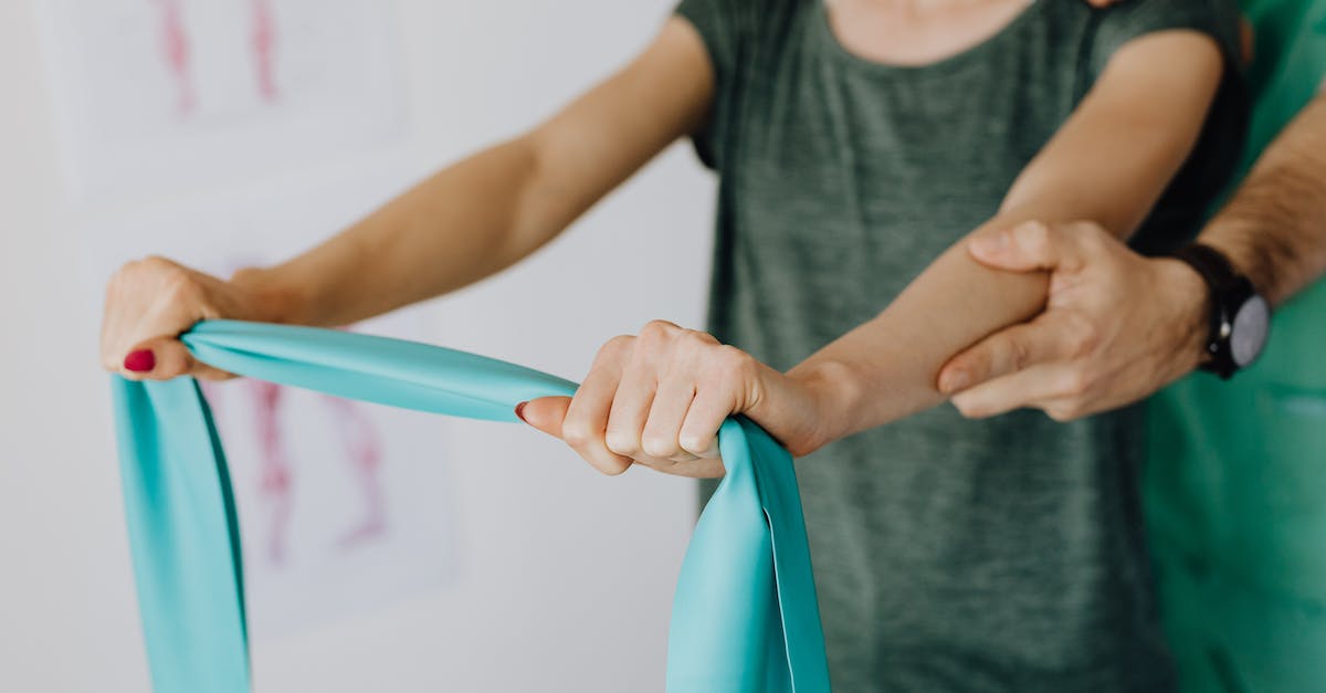 How do I reach the Arch-Mage? [duplicate] - Crop unrecognizable orthopedist in uniform and wristwatch supporting shoulder and reached arm of faceless female patient with resistance band in doctor office