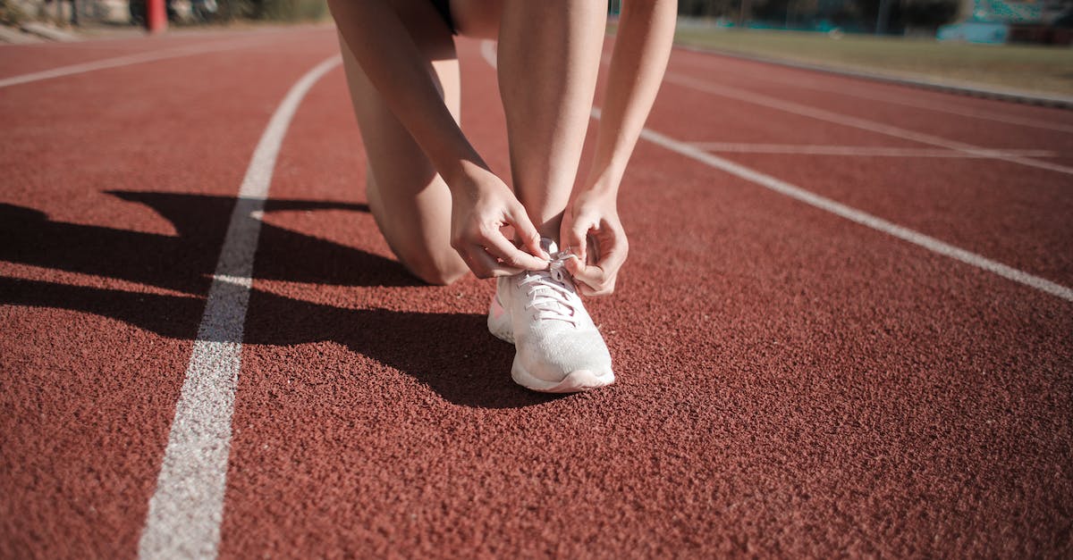 How do I run Counter-Strike 1.6 in Zombie mode? [closed] - Close-up Photo of Woman Tying Her white Sneakers on Running Track