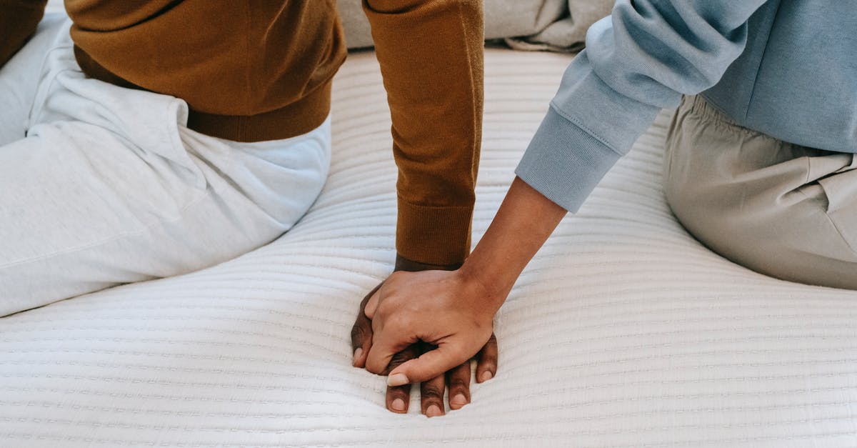 How do I separate enchants from items? - Crop unrecognizable black couple holding hands on bed