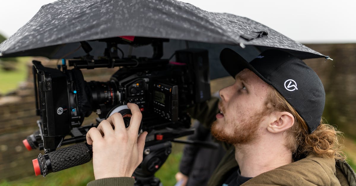 How do I set up my Panlong PL-G300 Mini PS2 to HDMI Video Converter? - A Side View of a Man Filming Outside while Raining