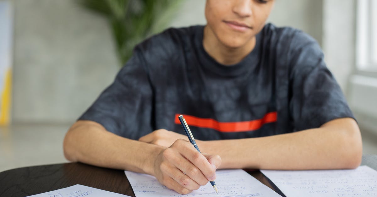 How do I solve Secret Note #16? - Crop African American male student taking notes on piece of paper at table while studying subject in classroom on blurred background