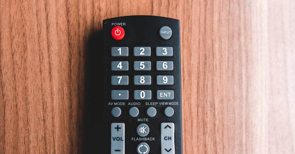 How do I switch modes on DOSBox? - Top view of plastic remote control with rows of buttons representing power and mute symbols on brown background How do I switch modes on DOSBox? - Top view of plastic remote control with rows of buttons representing power and mute symbols on brown background