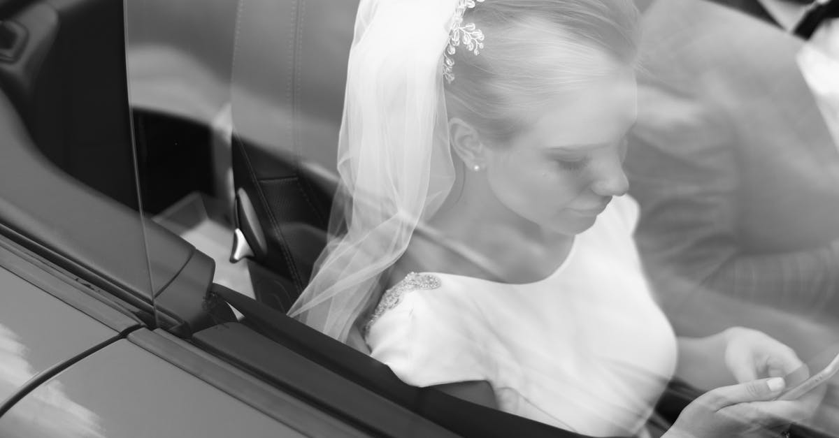 How do I transfer my previous Grand Theft Auto Online character? - From above black and white of woman in veil text messaging on cellphone near crop anonymous man in automobile on wedding day