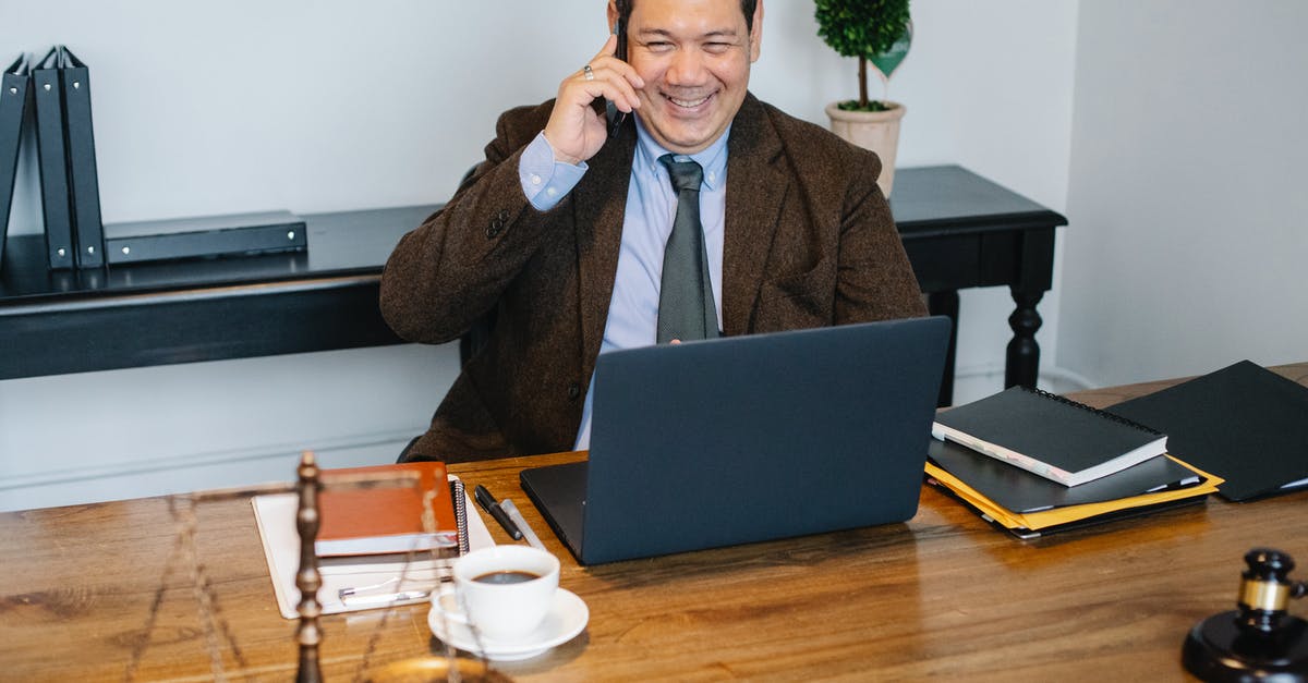 How do I unlock Expert Mode on mobile? [duplicate] - Joyful Asian male lawyer wearing formal suit having conversation on mobile phone and using laptop while working in modern law firm