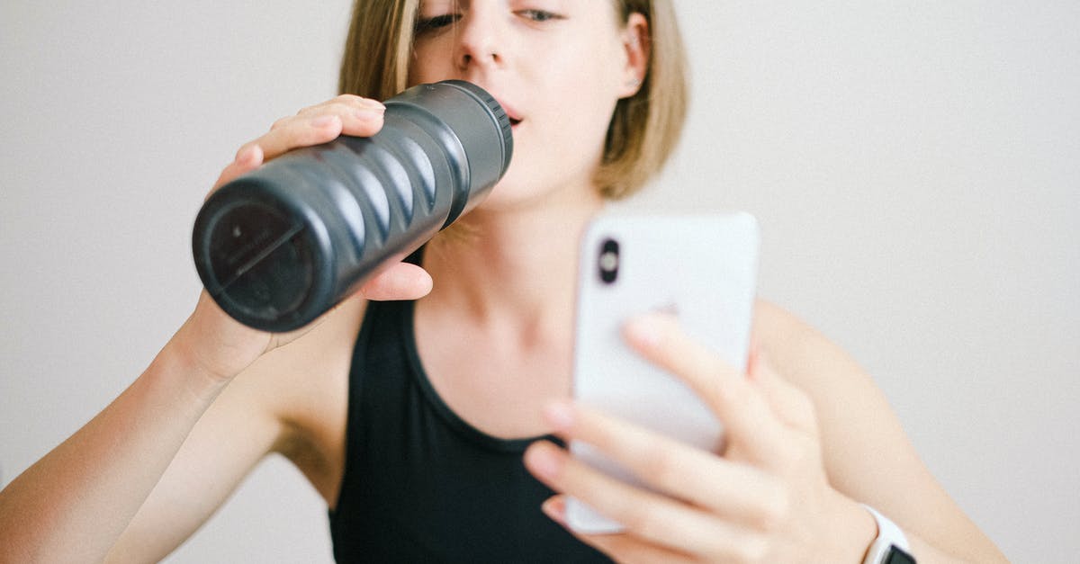 How do I unlock online levels in SMB? - Woman in Black Tank Top Holding White Smartphone While Drinking