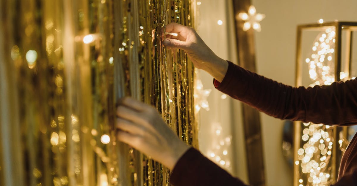 How do the Christmas decorations work? - Person in Black Long Sleeve Shirt Holding Gold String Lights