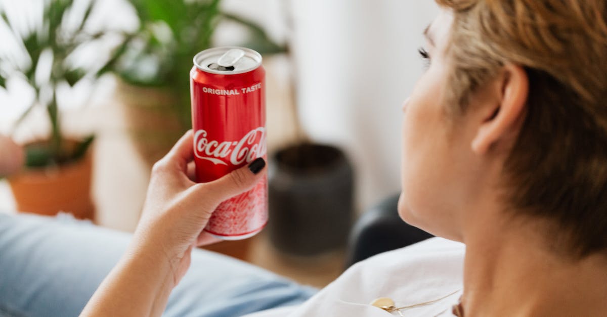 How do they compute the Gold and Elixir that can be looted? - Crop anonymous woman resting at home with can of coke
