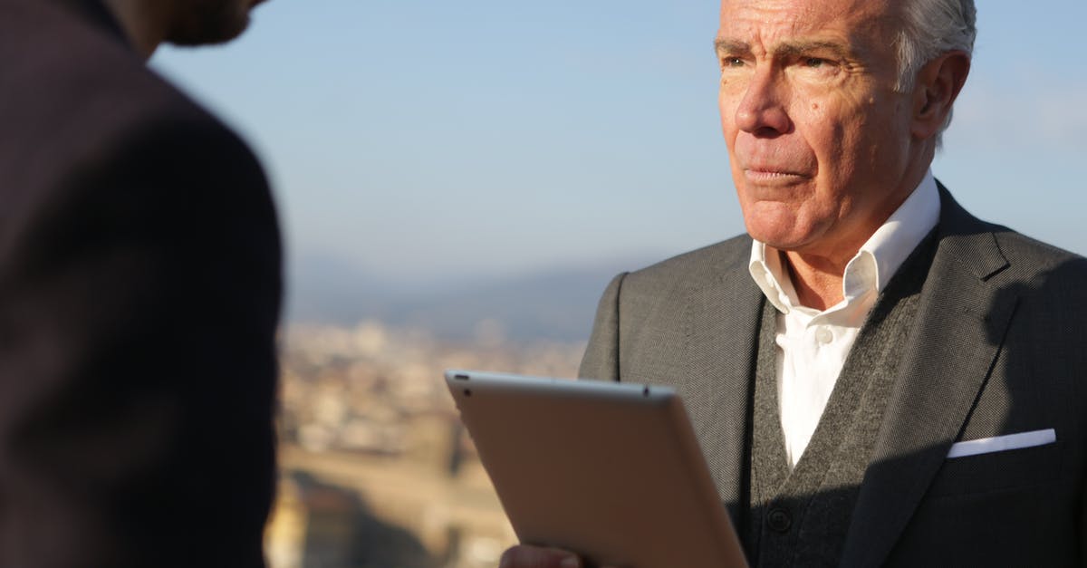 How do u recover your iPad clash of clans account without the old device [duplicate] - Man in Black Suit  Holding Silver Ipad Looking at Another Man