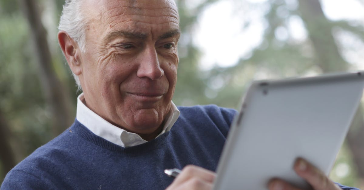 How do u recover your iPad clash of clans account without the old device [duplicate] - Man in Blue Sweater Holding Silver Ipad