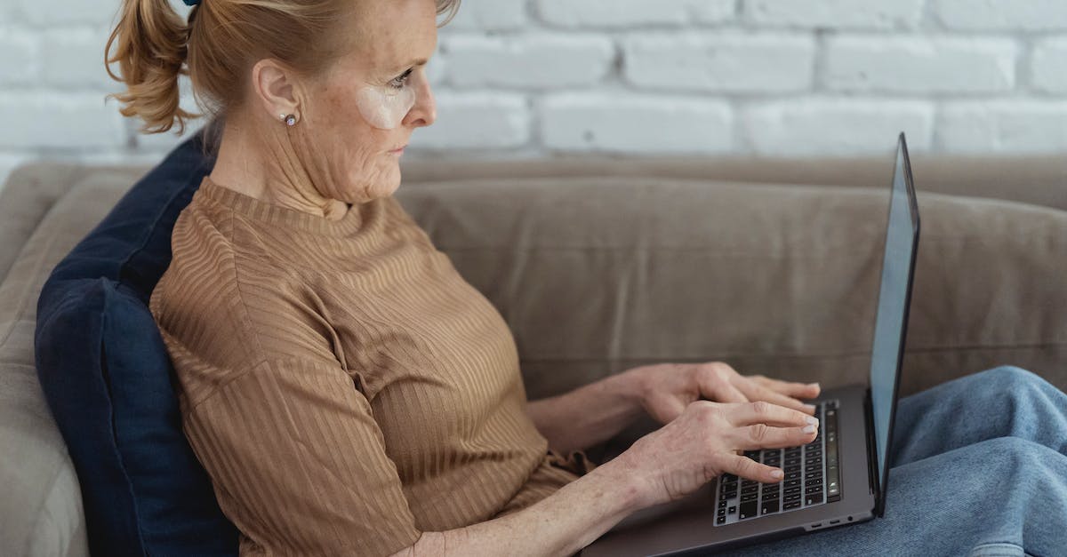 How do Wii U patches work? - Side view crop concentrated mature female wearing eye patches surfing contemporary netbook on laps while lying on comfy couch at home