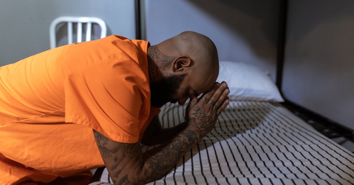 How do you become a prisoner in your own prison? - Man in Orange T-shirt Praying on Bed How do you become a prisoner in your own prison? - Man in Orange T-shirt Praying on Bed
