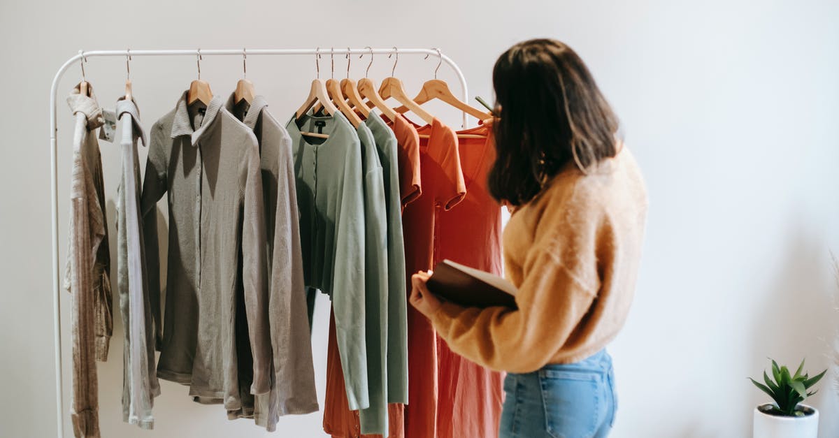 How do you check for a custom banner? - Faceless female seller with notepad near clothes on hangers How do you check for a custom banner? - Faceless female seller with notepad near clothes on hangers