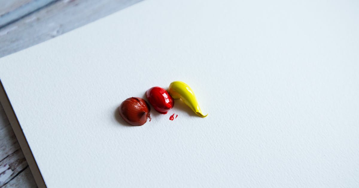 How do you clear the blocks in the end to create something? - From above of red and yellow paint blobs on clear white canvas placed on wooden surface in light art studio How do you clear the blocks in the end to create something? - From above of red and yellow paint blobs on clear white canvas placed on wooden surface in light art studio