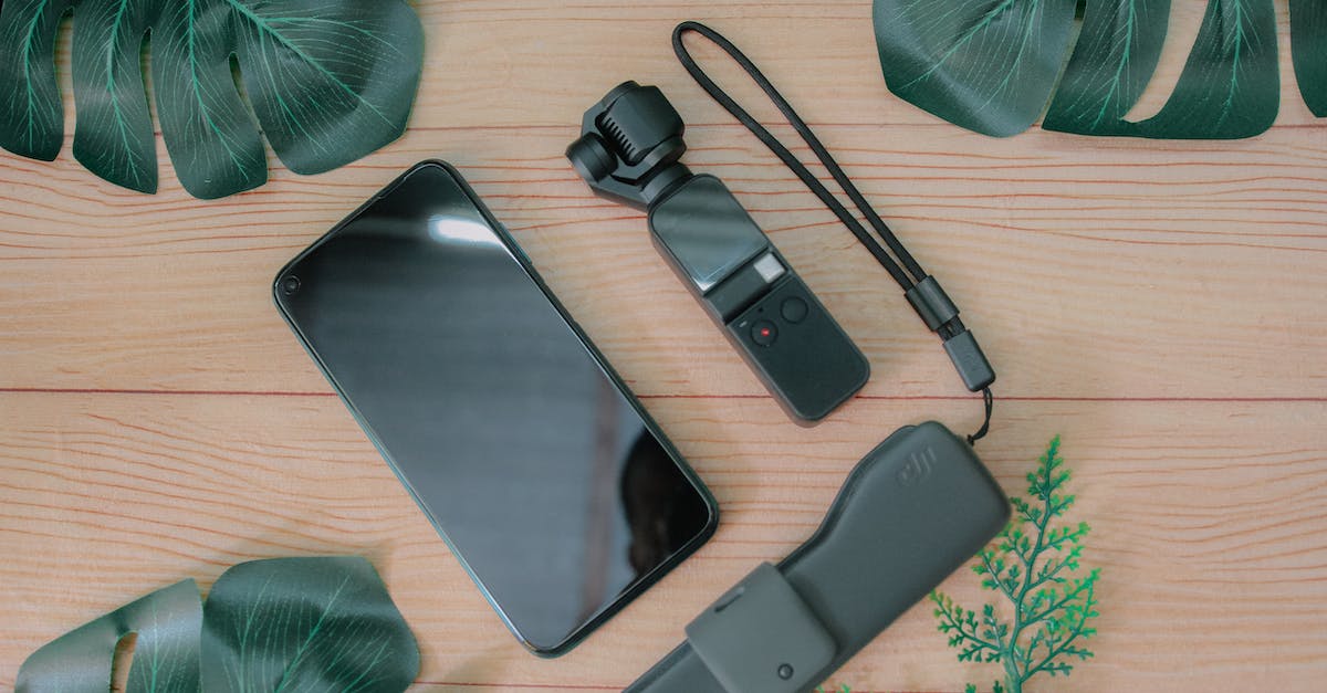 How do you download a game purchased from the xbox marketplace to a USB flash drive? - Top view composition of mobile phone placed near USB flash drive and mini gimbal camera on wooden table with green foliage