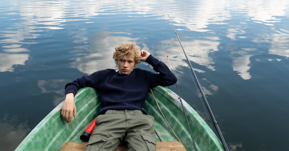 How do you find a fishing rod in Terraria for PS Vita? - Teenager Resting in Green Boat Floating on Calm Waters