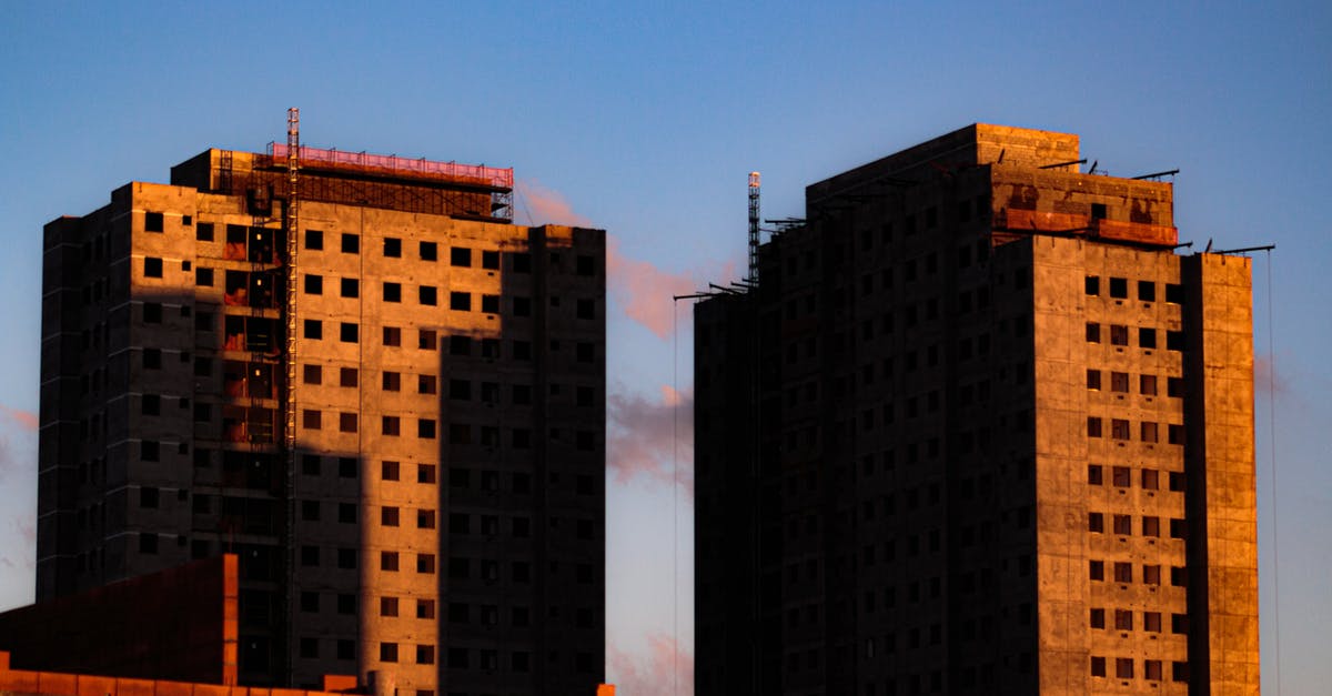 How do you get to build new RZs? - From below of tall concrete houses under construction at sunlight against blue sky How do you get to build new RZs? - From below of tall concrete houses under construction at sunlight against blue sky