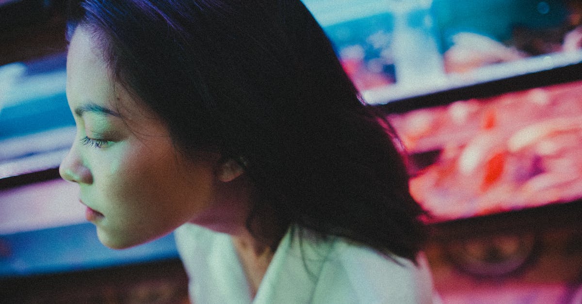 How do you headshot a Bastion in Sentry or Tank configuration? - From above young Asian female with closed eyes while standing on blurred background of fish tanks