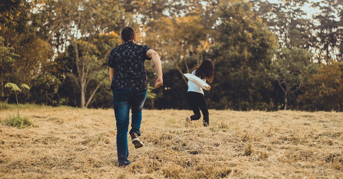 How do you land safely at the beginning of the game? - Unrecognizable couple running on meadow in park How do you land safely at the beginning of the game? - Unrecognizable couple running on meadow in park