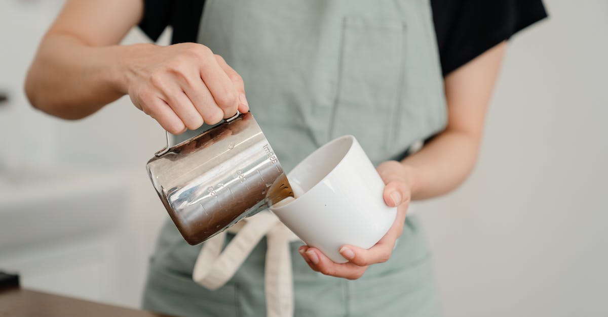 How do you make stacked houses? - Crop unrecognizable barista in apron pouring milk from steel pitcher to white ceramic cup while preparing aromatic coffee in modern cafe How do you make stacked houses? - Crop unrecognizable barista in apron pouring milk from steel pitcher to white ceramic cup while preparing aromatic coffee in modern cafe