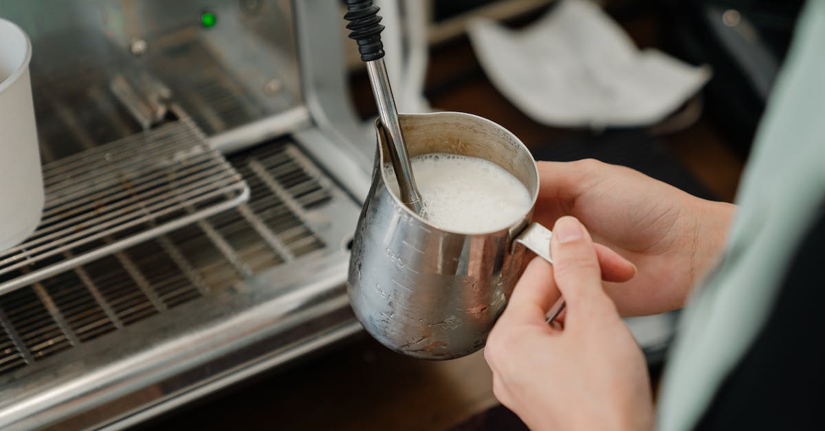How do you make stacked houses? - Crop barista whipping milk in stainless steel cup How do you make stacked houses? - Crop barista whipping milk in stainless steel cup