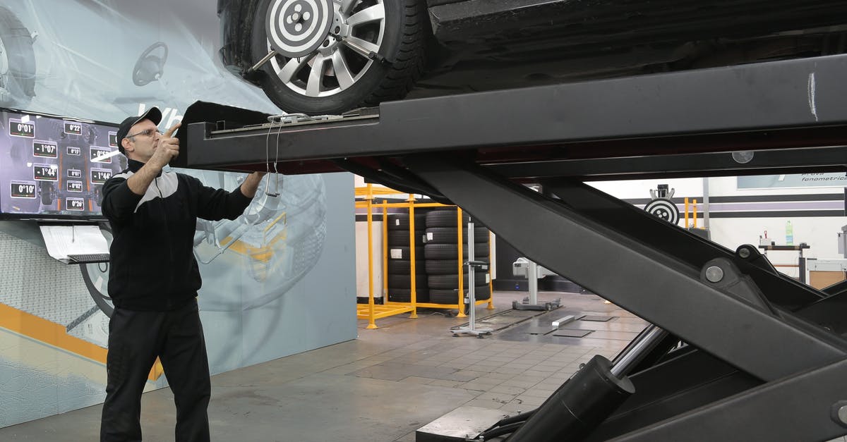 How do you operate the elevator in Stellar Bay? - Serious mechanic checking car wheels on lift in modern car service garage How do you operate the elevator in Stellar Bay? - Serious mechanic checking car wheels on lift in modern car service garage