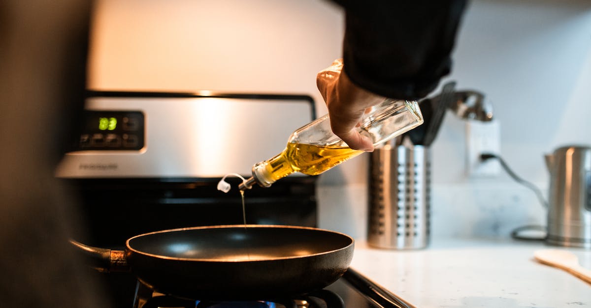How do you pump Creosote Oil out of a Coke Oven - Back view crop unrecognizable person pouring olive or sunflower oil into frying pan placed on stove in domestic kitchen