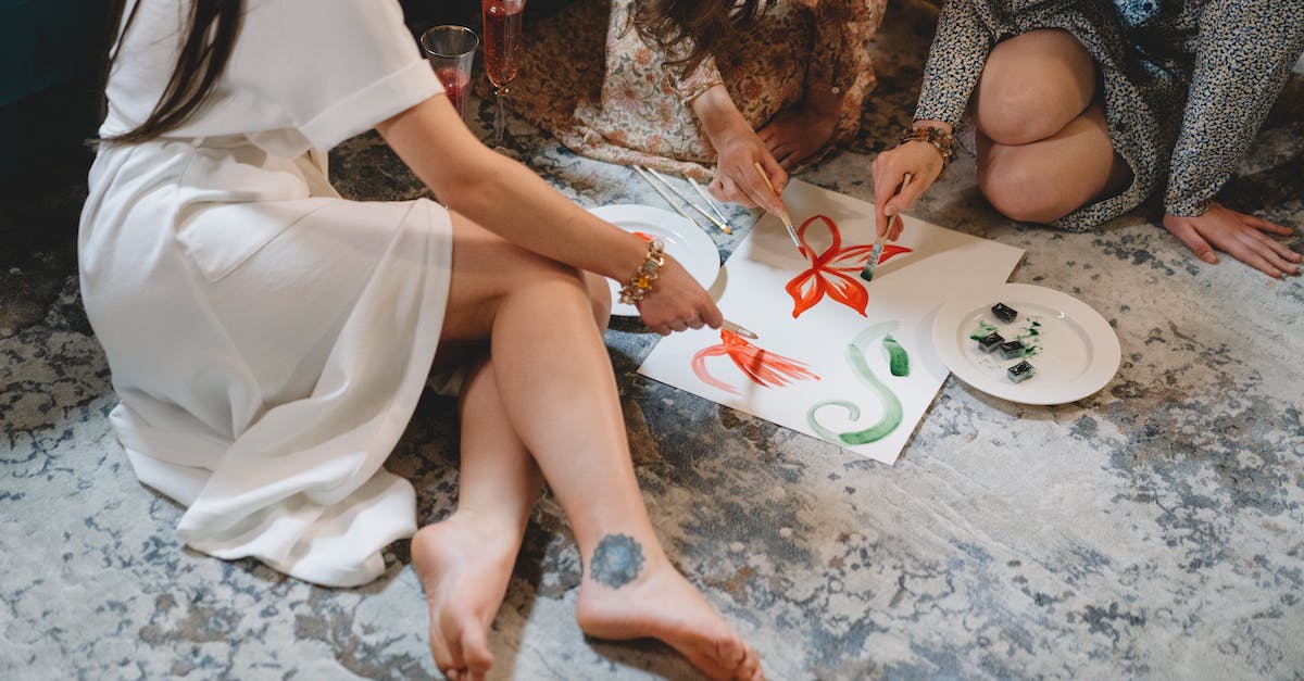How do you put paint onto a paintbrush? - Woman in White Dress Sitting on Floor How do you put paint onto a paintbrush? - Woman in White Dress Sitting on Floor
