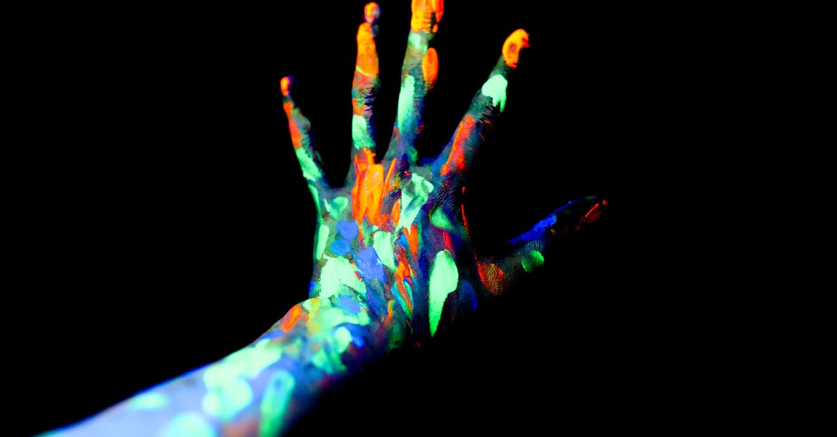 How do you reach this obscure Chrono Trigger scene? - Crop unrecognizable persons hand with fingers spread covered with bright neon paints in dark studio How do you reach this obscure Chrono Trigger scene? - Crop unrecognizable persons hand with fingers spread covered with bright neon paints in dark studio