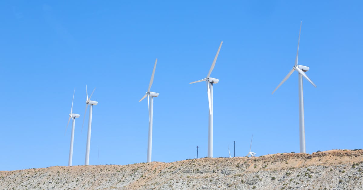 How do you remove a station from a line? - Vibrant blue cloudless sky over tall white wind turbines on slope in empty field in daytime