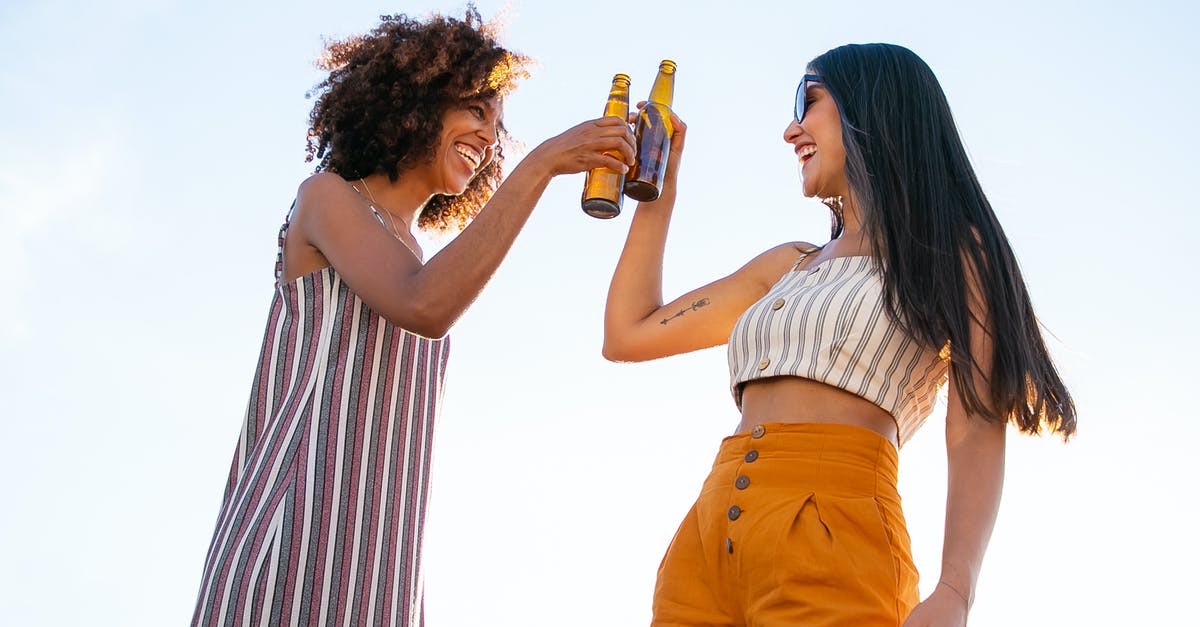 How do you unlock each party member? - Low angle of delighted multiracial female friends toasting with bottles of beer while laughing together during party