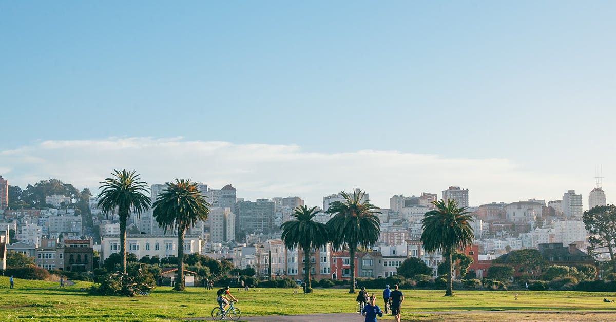 How do you unlock the speed run mode? - People jogging and riding bike on asphalt pathway in green park with palm trees and lawn near city