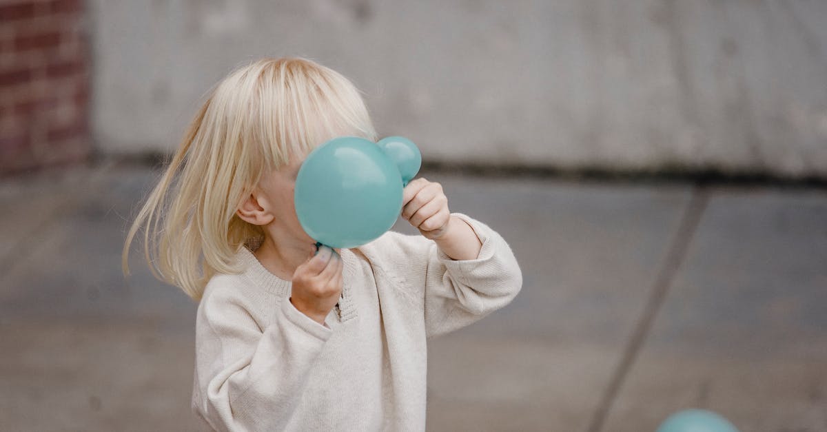 How does Angel have a brain the size of a planet? - Anonymous blond kid in casual apparel playing with blue balloons on city street in daylight