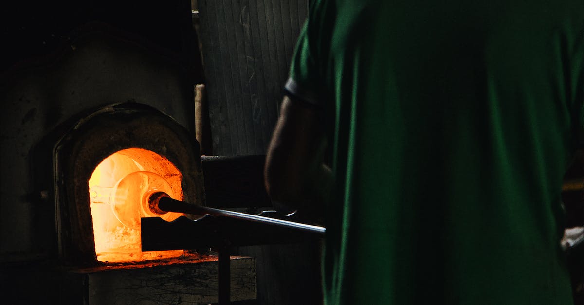 How does class progression for unlockable passives and skills/combat arts work in Fire Emblem 3 houses? - Back view of crop unrecognizable professional worker standing in front of furnace while blowing glass in workshop