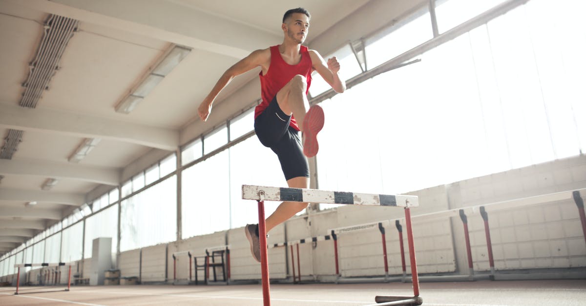 How does Crouch jump actually work? - Powerful male athlete jumping over hurdle on running track while training at sports hall How does Crouch jump actually work? - Powerful male athlete jumping over hurdle on running track while training at sports hall