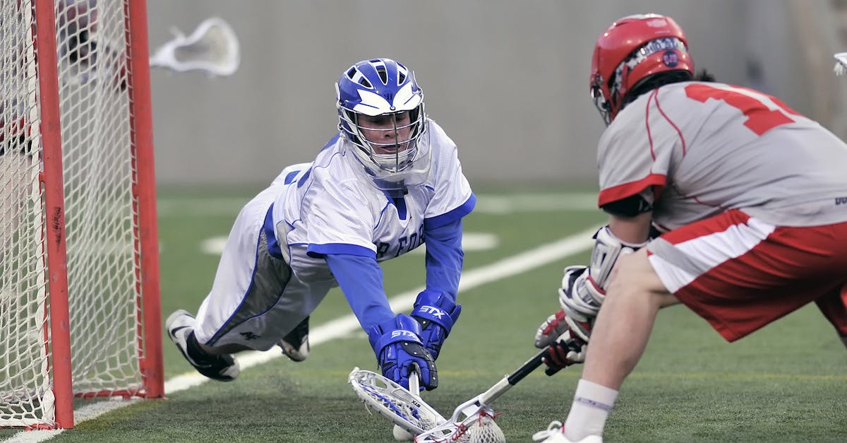 How Does Defense On Helmets Work? - Person Wearing Blue Gloves Holding Lacrosse Stick How Does Defense On Helmets Work? - Person Wearing Blue Gloves Holding Lacrosse Stick