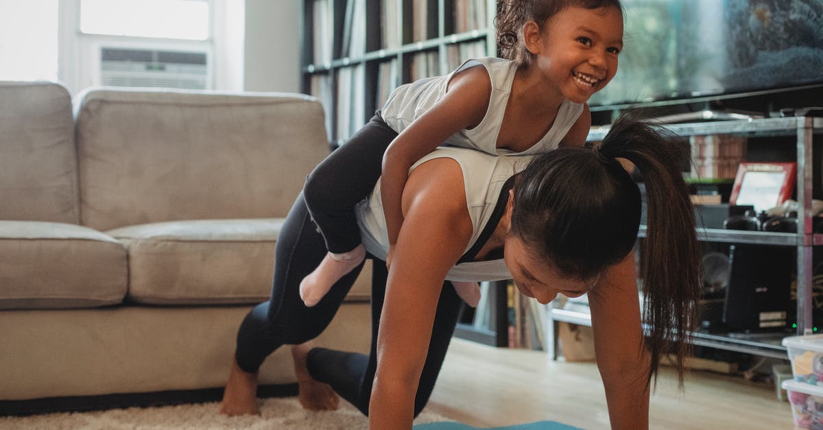 How does difficulty level affect my exercise? - Young Asian woman piggybacking smiling daughter while exercising at home How does difficulty level affect my exercise? - Young Asian woman piggybacking smiling daughter while exercising at home