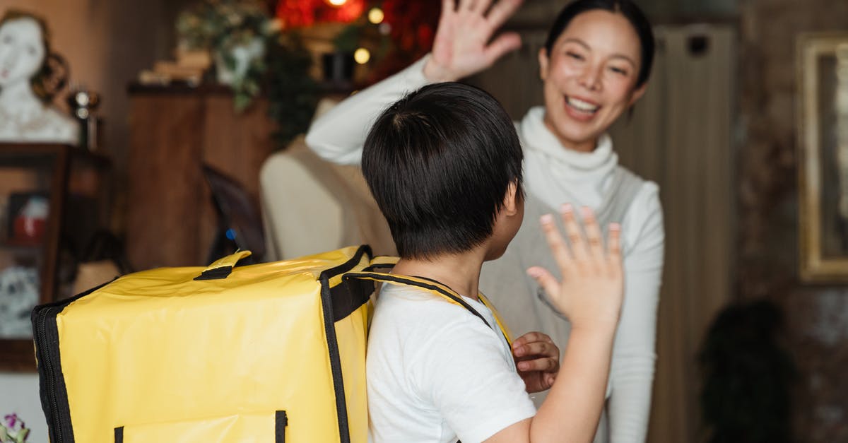 How does Mother Base staff morale work? - Happy ethnic female cafe worker in apron wishing farewell to boy with food delivery backpack helping in family business