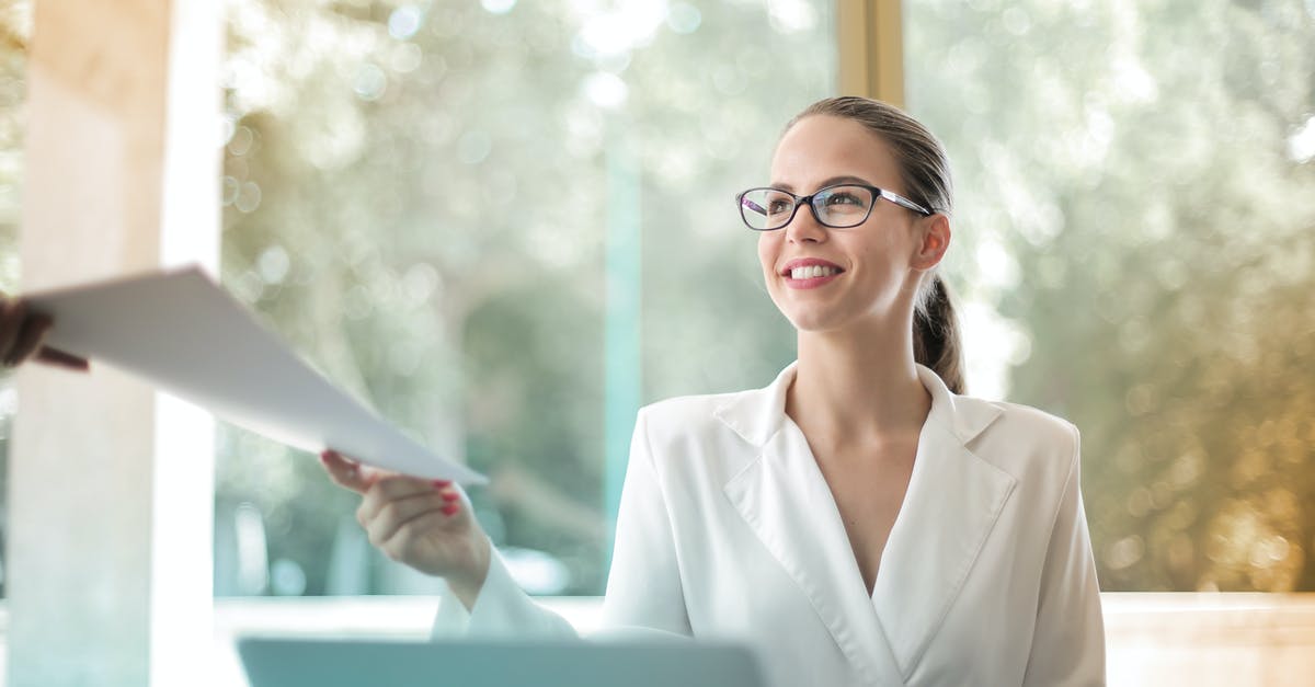 How does outfit unlocking work? - Low angle of successful female executive manager in classy style sitting at table with laptop in contemporary workplace and passing documents to colleague How does outfit unlocking work? - Low angle of successful female executive manager in classy style sitting at table with laptop in contemporary workplace and passing documents to colleague
