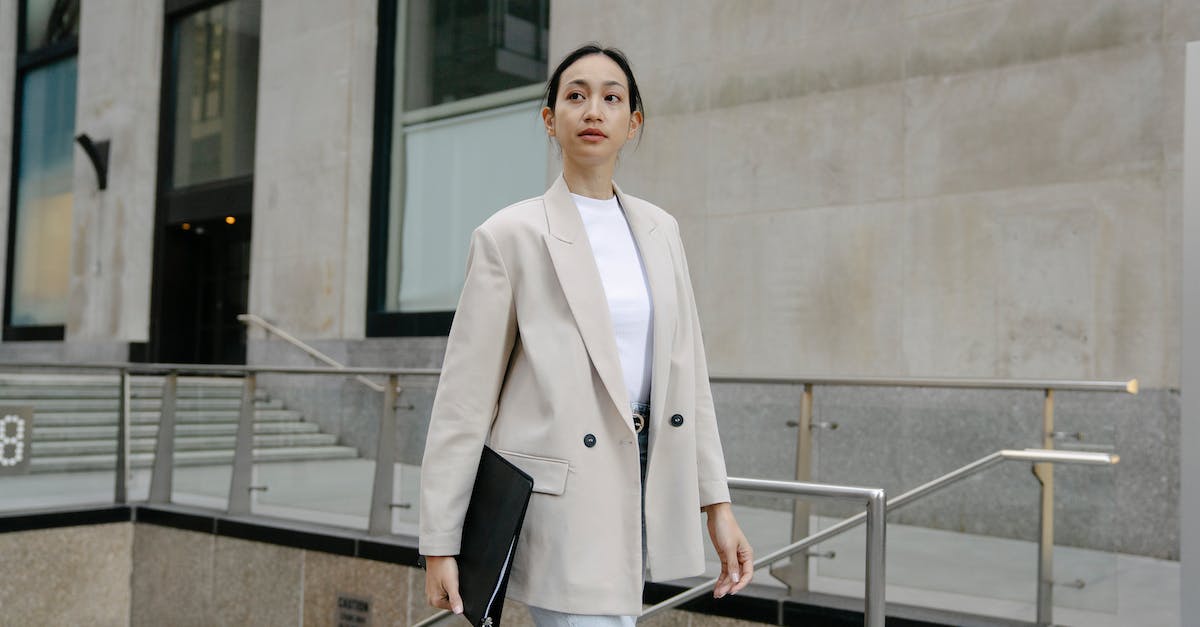 How does personality reputation work? - Confident Asian female entrepreneur in stylish outfit and with folder walking in city street and looking away How does personality reputation work? - Confident Asian female entrepreneur in stylish outfit and with folder walking in city street and looking away