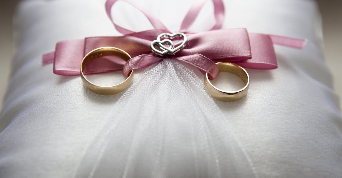 How does the life-draining effect of Bul-Kathos's Wedding Band work? - Selective Focus Photography of Silver-colored Engagement Ring Set With Pink Bow Accent on Throw Pillow
