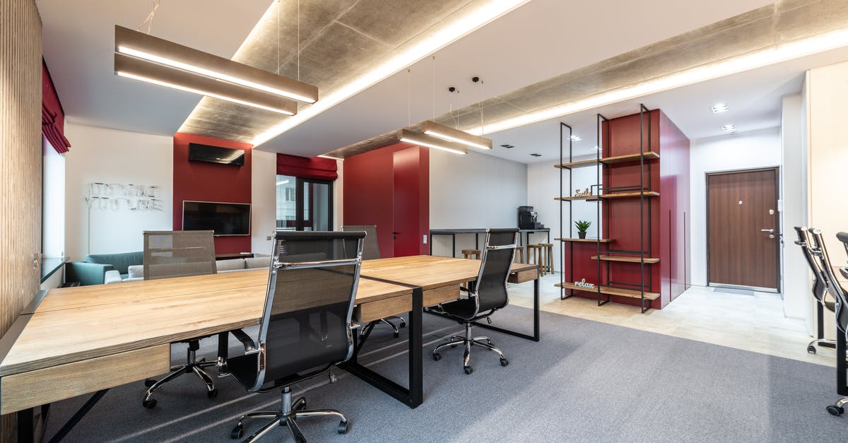 How does Xbox One work with Microsoft's TV tuner and TV itself? - Office interior with table and chairs near shelves